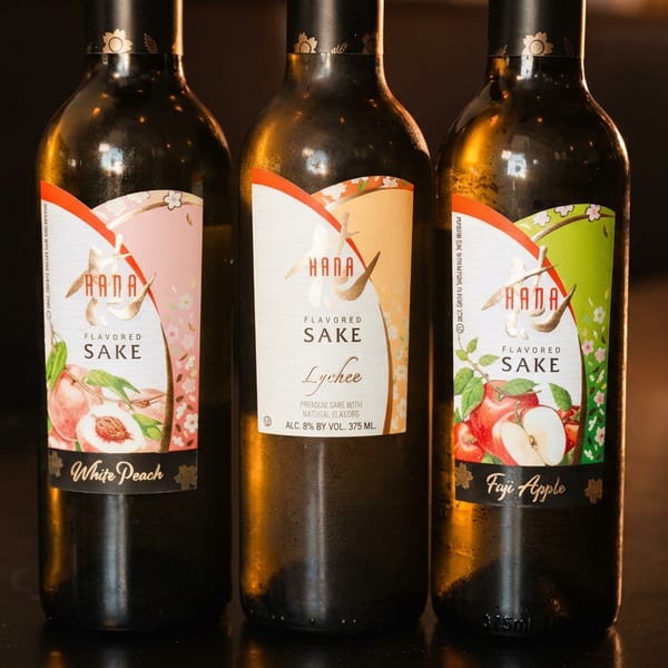 Three Hana flavored sake bottles: White Peach, Lychee, and Fuji Apple.